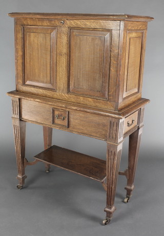 An Edwardian Art Nouveau rectangular cocktail cabinet, the fall front revealing a fitted interior having 2 drawers to the side and 1 to the centre, raised on square tapering supports with undertier 52"h x 33 1/2"w x 16"d 