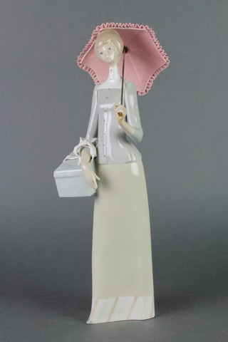 A Lladro figure of a lady carrying a parcel with a parasol 14" 