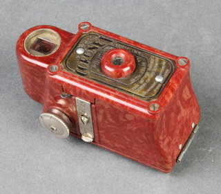 A Coronet midget camera contained in a red Bakelite case 