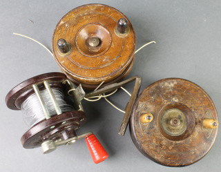 2 wooden and brass centre pin fishing reels and a Bakelite multiplying fishing reel