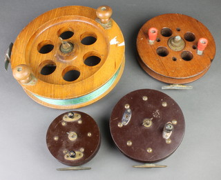 2 large wooden and brass centrepin fishing reels 12" and 8 1/2", 2 Bakelite centrepin fishing reels 7" and 5" 