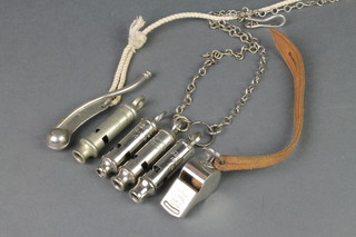 A Bosuns whistle, an Acme military issue whistle marked 673-6266 and 3 Police style whistles