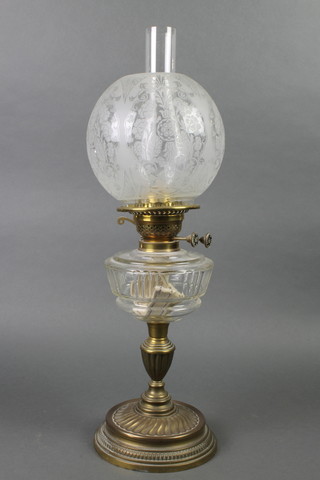 A Victorian glass and brass oil lamp with etched shade, raised on a brass base 24"h 
