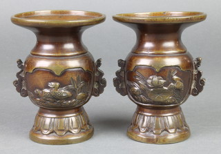 A pair of 19th Century Japanese bronze vases with panels decorated birds amidst leaves, raised on circular spreading feet 4 1/2" 