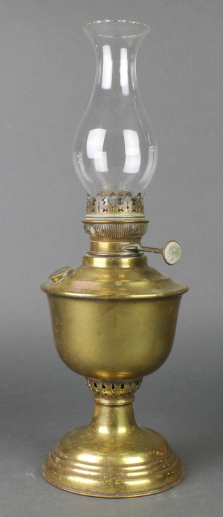 A brassed bell shaped oil lamp complete with clear glass chimney