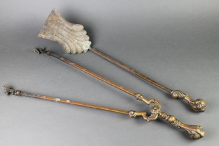 A Victorian 2 piece brass fireside companion set with tongs and shovel, the handle in the form of a claw clenching a ball