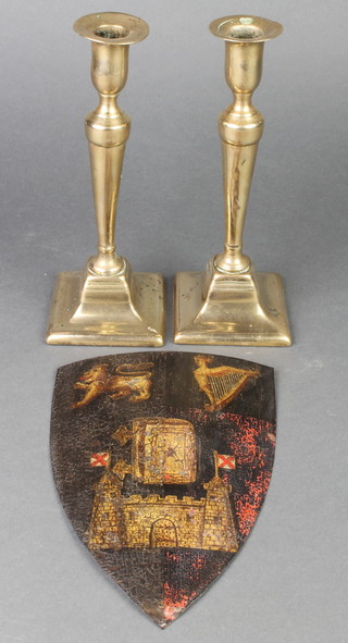 A pair of 19th Century brass Adam style candlesticks with ejectors 8 1/2" and a Victorian painted armorial shield 8" 