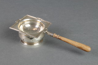 An Art Deco silver tea strainer and stand with fruitwood handle, Birmingham 1929