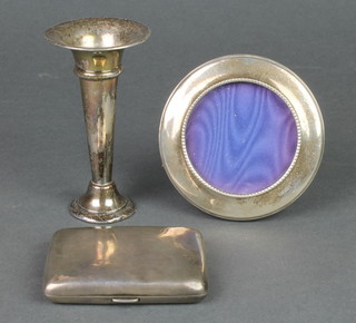 A silver cigarette case, ditto circular silver photograph frame and a tapered spill vase 