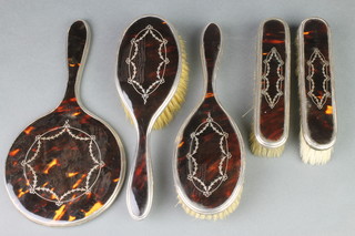 A silver and tortoiseshell pique brush set comprising 2 clothes, 2 hair brushes and a mirror 