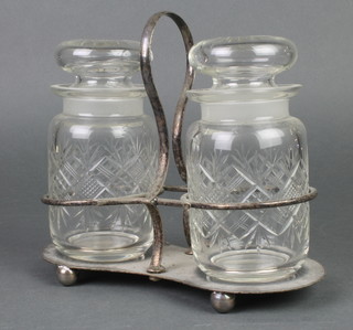 A pair of cut glass bottles in a plated stand
