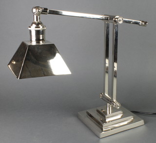 A silver plated desk lamp on a stepped base