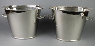 A pair of large silver plated oval champagne coolers with twin handles