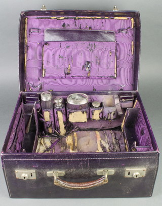 A leather toilet case containing 4 silver mounted bottles, London 1914