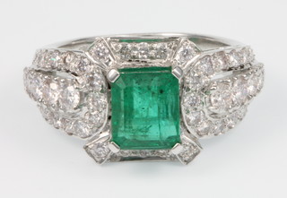 A 14ct white gold emerald and diamond cocktail ring, the centre stone approx 3.2 ct. surrounded by brilliant diamonds approx. 1.6ct, size P 1/2