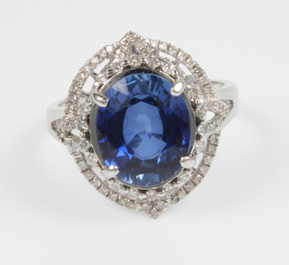 A 14ct white gold diamond and oval cut sapphire open ring, the centre stone approx. 5ct surrounded by brilliant diamonds approx. 0.5ct, size M 1/2
