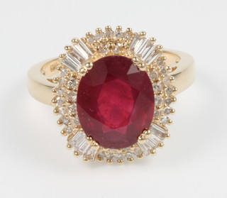 A 14ct yellow gold ruby and diamond cluster ring, the oval ruby approx. 5.4ct, surrounded by 1.1ct of diamonds, size M 1/2