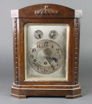 An Edwardian chiming bracket clock with silvered dial and Arabic numerals contained in an arched oak case 