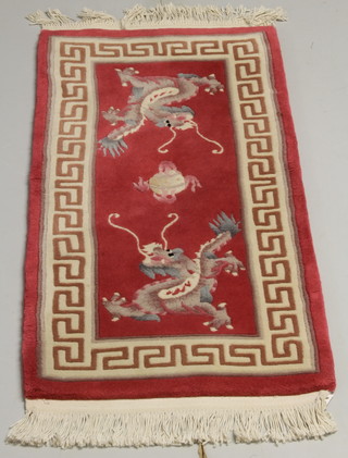 A red ground Chinese rug decorated dragons 51" x 24" 