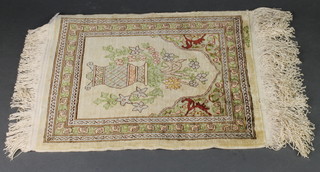 A cream ground silk Persian rug with mihrab decorated an urn of flowers, signed 15" x 12" 