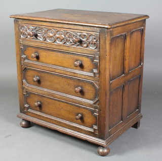 A Jacobean style carved oak chest of 4 long drawers with geometric mouldings and turned handles, raised on squashed bun feet 30"h x 28"w x 18"d  