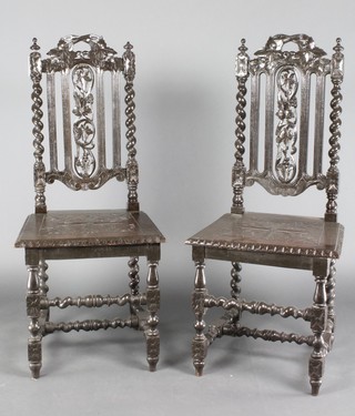 A pair of Victorian Carolean style ebonised hall chairs with solid seats, raised on spiral turned supports 