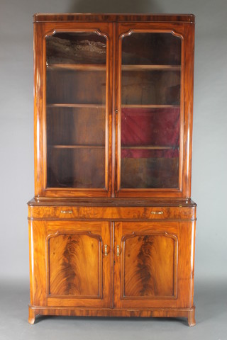 A 19th Century Continental mahogany bookcase on cabinet, the upper section with moulded cornice, the interior fitted adjustable shelves enclosed by arch panelled doors, the base fitted 1 long drawer above a cupboard enclosed by panelled doors, raised on bracket feet 96"h x 51"w x 21"d 