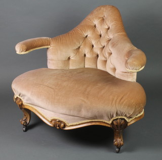A Victorian metal framed armchair upholstered in mushroom buttoned material and with carved walnut legs 