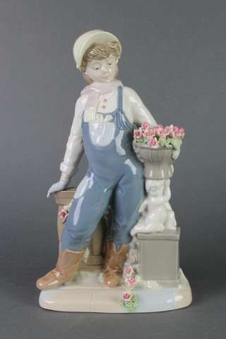 A Spanish figure of a young man standing beside an urn of flowers 12" 