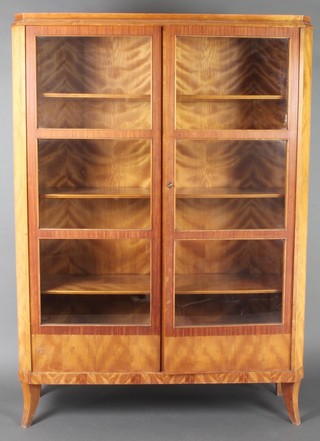 Anl Art Deco walnut display cabinet fitted adjustable shelves enclosed by glazed panelled doors, raised on outswept supports, the reverse marked Schenker & Co Berlin 67 1/2"h x 47"w x 14"d 