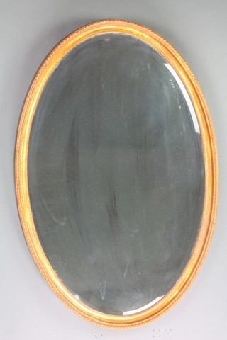 An oval bevelled plate wall mirror contained in a decorative gilt frame 38"h x 25 1/2"w 