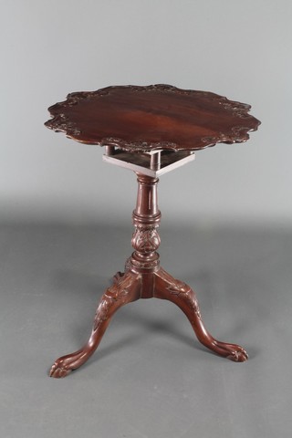 A Georgian style mahogany circular snap top supper table with pie crust edge and bird cage action, raised on carved pillar and tripod base 28"h x 23" diam. 