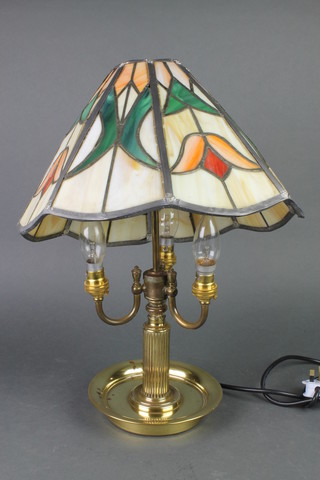 A brass 3 light desk lamp with red glazed leaded shade 
