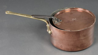 A circular copper saucepan with brass handle complete with lid marked BTHS, 12" 