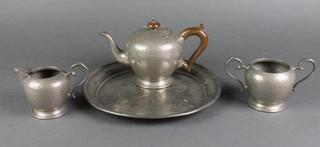 A Tudor planished pewter 3 piece tea service comprising cream jug, sugar bowl and teapot, the base marked 2313, together with a circular pewter tray 10" 