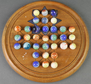 A turned wood solitaire board with marbles 8 1/2" 