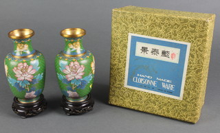 A pair of cloisonne green ground and floral patterned club shaped vases on hardwood stands 5 1/2", cased 