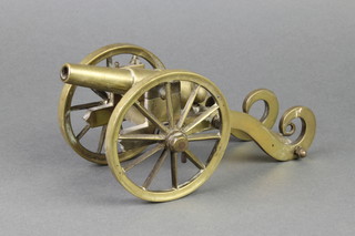 A brass model of a canon with 5" barrel, missing hub nut to one of the wheels