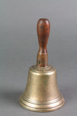 A brass hand bell with turned wooden handle