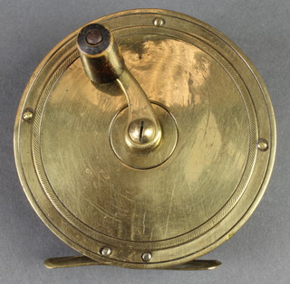 A circular brass 3 1/2" fishing reel 