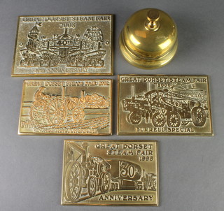 A circular brass table bell, 4 brass commemorative plaques for The Great Dorset Steam Fair 1998, 2000, 2002 and 2008 