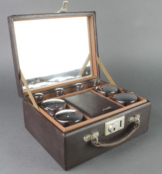 A 1930's leather vanity case, fitted 4 rectangular bottles with chrome lids and 4 circular jars with chrome lids 