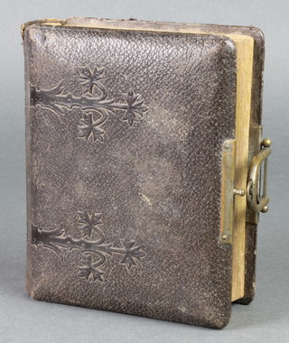 A Victorian leather bound photograph album containing various black and white photographs 