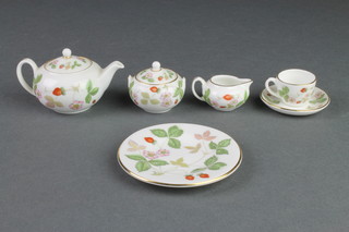 A Wedgwood miniature tea set with strawberry decoration comprising teapot, sugar bowl, cream jug, tea cup, saucer and plate