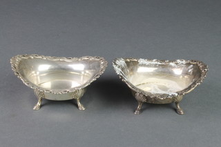 A pair of Edwardian silver boat shaped bon bon dishes on shell knees and pad feet, London 1908, 248 grams