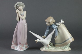 A Lladro figure of a young girl holding a flower. 5646 8" and a ditto of a girl catching a goose. 550 7" 
