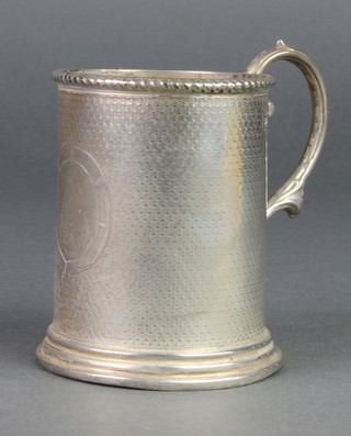A Victorian silver engine turned mug with S scroll handle and vacant cartouche, London 1870, 118 grams 