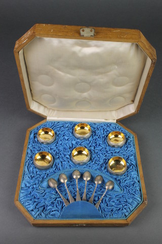 An early 20th Century Russian silver 6 piece table salt set with chased decoration and gilt interiors on ball feet with 6 spoons in a fitted octagonal case 