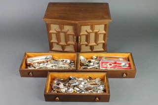 A quantity of souvenir spoons in a fitted cabinet