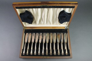 A walnut canteen containing a set of silver plated fish eaters for 12 